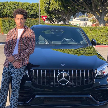 Marcus Scribner posing in front of his Mercedes.